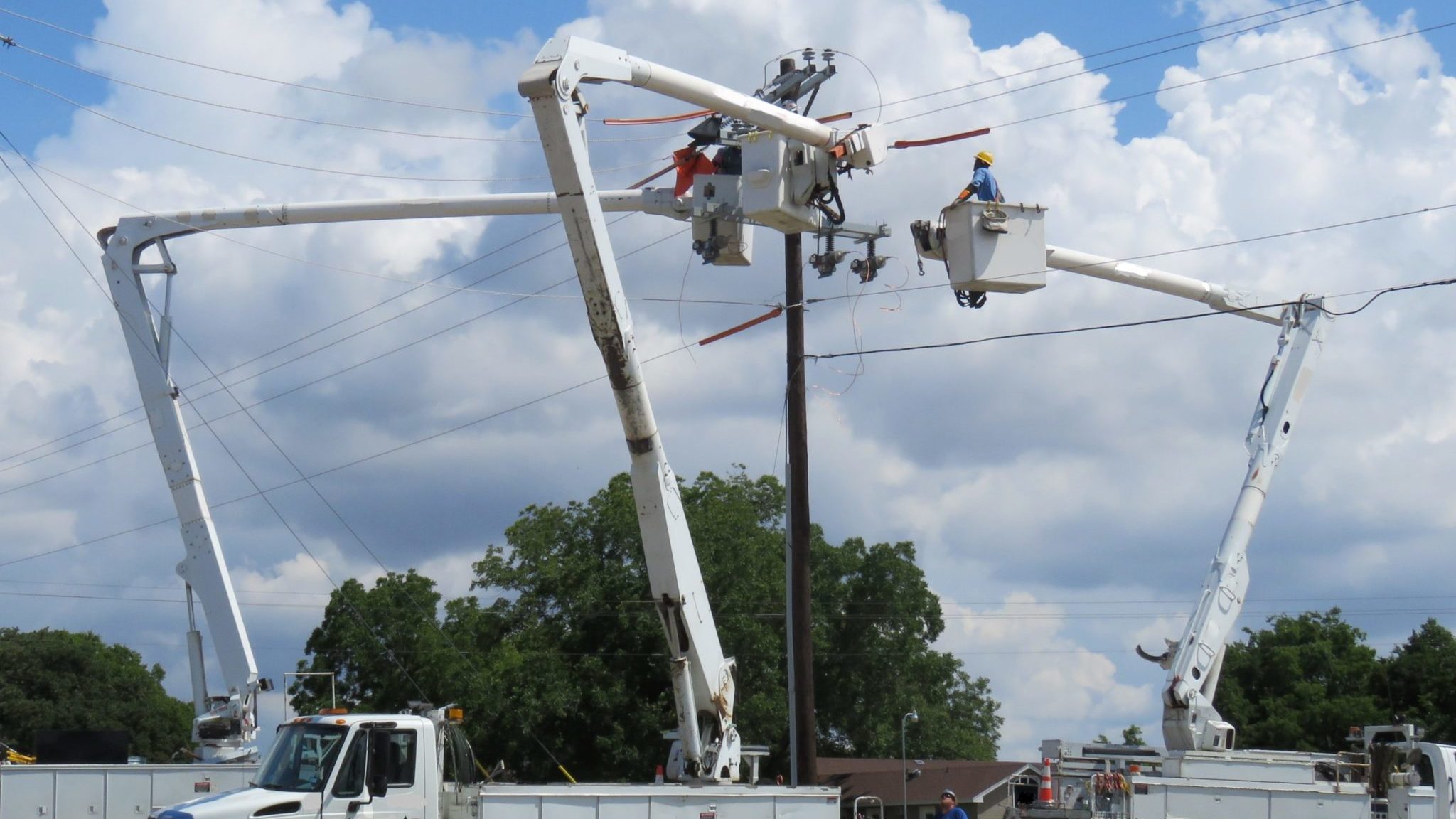 linemen in utility truck working on electrical equipment